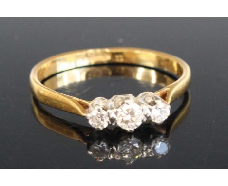 A yellow and white metal diamond three stone ring comprising three graduated round brilliant cut diamonds in claw settings. D