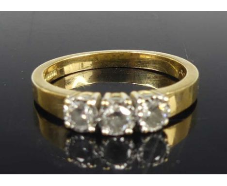 An 18ct gold diamond three-stone ring, arranged as three bezel set round cuts in a line setting, total diamond weight stated 