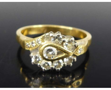A contemporary yellow metal diamond wishbone ring, arranged as a centre round brilliant within a surround of six further roun