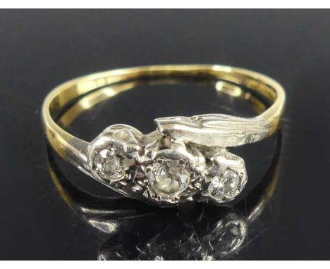 A yellow and white metal diamond three-stone crossover ring, having three graduated Old European cut diamonds in illusion set