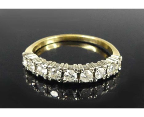 An 18ct gold and platinum diamond half eternity ring, arranged as nine four-claw set round brilliants, total diamond weight e