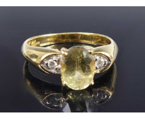An 18ct gold peridot and diamond three-stone ring, arranged as a four-claw oval cut peridot measuring approx 8 x 6 x 4mm, fla