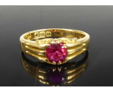 An 18ct gold ruby solitaire ring, the claw set round cut ruby weighing approx 0.5 carats, hallmarks worn but with Birmingham 