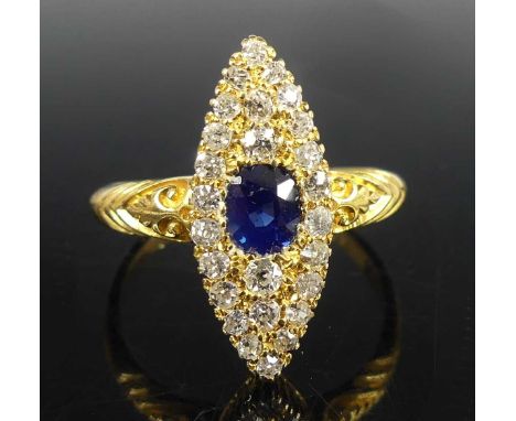 An 18ct yellow gold, sapphire and diamond navette cluster ring, featuring a centre oval sapphire within a border of 26 Old Eu