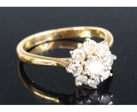 A yellow and white metal diamond circular cluster ring featuring 9 round brilliant cut diamonds in claw settings. Centre diam
