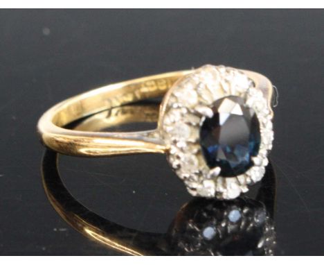 An 18ct gold sapphire and diamond oval cluster ring, the centre sapphire within a border of 10 single cut diamonds all in cla