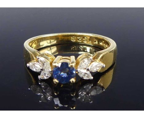 A contemporary 18ct gold, sapphire and diamond dress ring, arranged as a centre four-claw set round cut sapphire weighing app