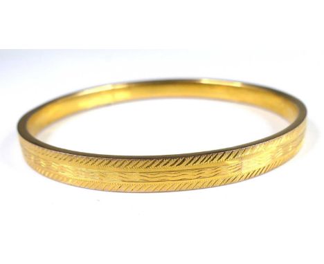 A George V 9ct gold hollow bangle, of rectangular section with bright cut banded decoration, Birmingham 1924, sponsor STP, 9.