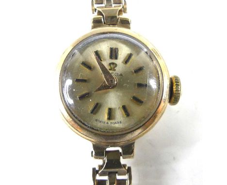 A lady's Omega 9ct gold cased wristwatch, having a signed champagne dial with baton markers, manual wind movement, case dia.1