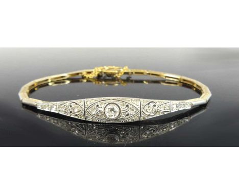 A yellow and white metal diamond articulated link bangle, comprising a central pierced section with a transitional brilliant 