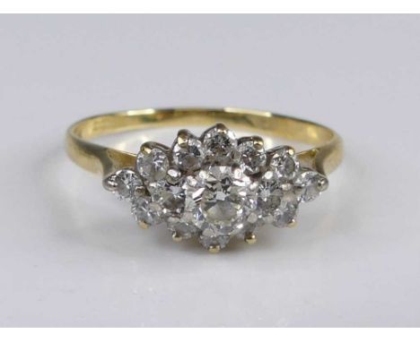 An 18ct gold diamond lozenge cluster ring, arranged as fifteen claw set round brilliants in a tiered lozenge setting, total d