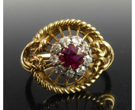 A contemporary yellow metal, ruby and diamond cluster ring, arranged as a centre claw set ruby weighing approx 0.45 carats, i
