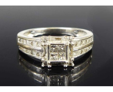 A modern 18ct white gold and diamond set dress ring, the square setting centre set with four princess cut diamonds, the corne