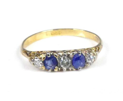 A yellow metal, sapphire and diamond carved half eternity ring, having two oval sapphires alternating with three graduated ol