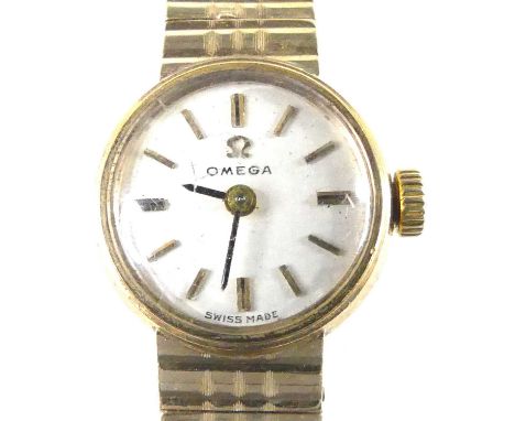 A lady's Omega 9ct gold cased bracelet watch, having a signed champagne dial with baton markers, manual wind movement, case d