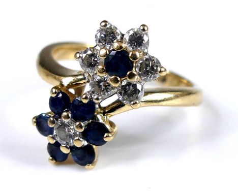 A contemporary 14ct gold, sapphire and diamond double flower head cluster ring, arranged as round brilliant cuts, total diamo