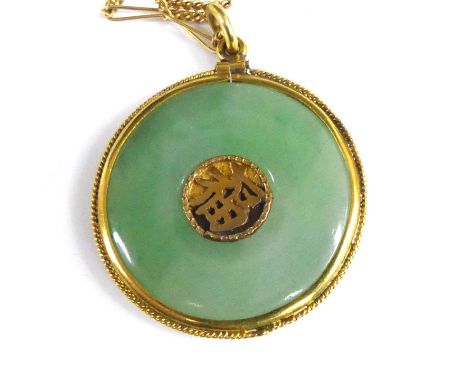 A Chinese yellow metal and jade disc pendant, indistinctly marked but tests as approx 18ct gold, dia.2.7cm, on yellow metal f