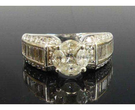 A white metal diamond dress ring, featuring a centre princess cut diamond within a border of four marquise cut diamonds, with