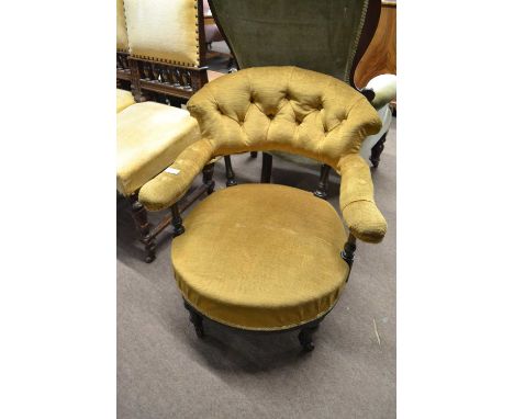 A late Victorian bow back button upholstered armchair with turned legs