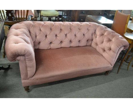 A small Victorian pink button upholstered Chesterfield style sofa on turned legs, 156cm wide