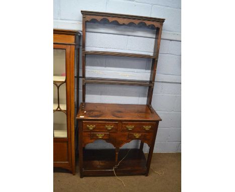 A George III style oak dresser of small proportions, the top section with moulded cornice and two shelves over a base with fo