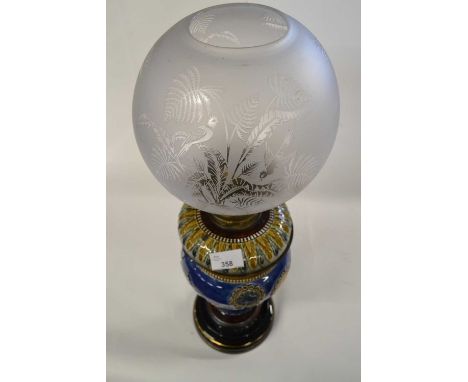 A Doulton oil lamp with globular white shade, the blue body with applied bird decoration, the matched reservoir with an incis