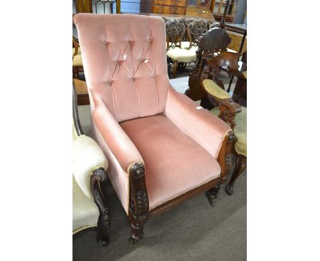 A Victorian pink button upholstered armchair set on a rose wood frame with carved acanthus leaf detail and turned legs with s