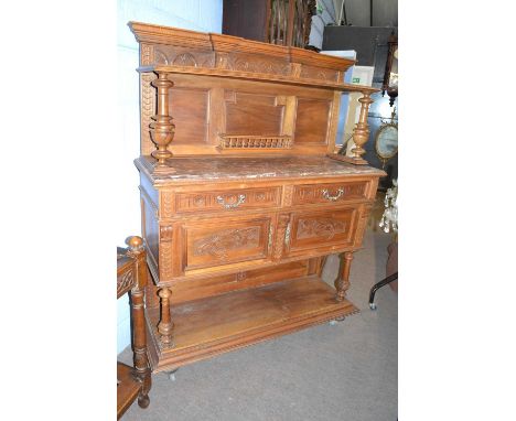 A late Victorian American walnut side or serving cabinet with a moulded cornice over a top shelf and a red marble surface, th