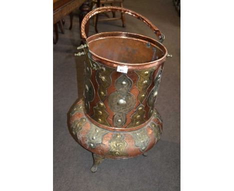 A large copper and brass mounted three footed bucket or planter, possibly of North African origin, 66cm high excluding handle