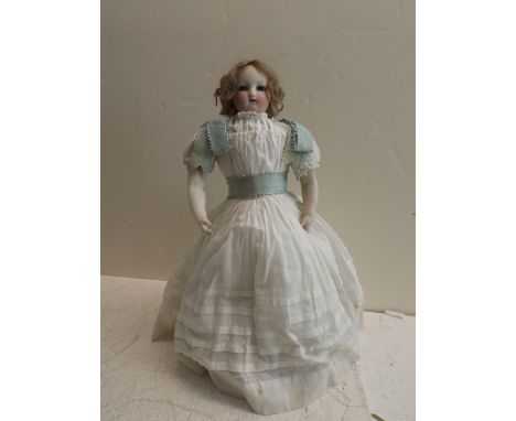 A late Victorian Automaton. The porcelain shoulder plate head and fore-arms on a kid fabric and wood frame. The whole on two 