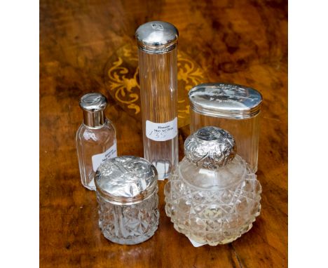 Five silver topped perfume, cologne and dressing table bottles including embossed and engine turned