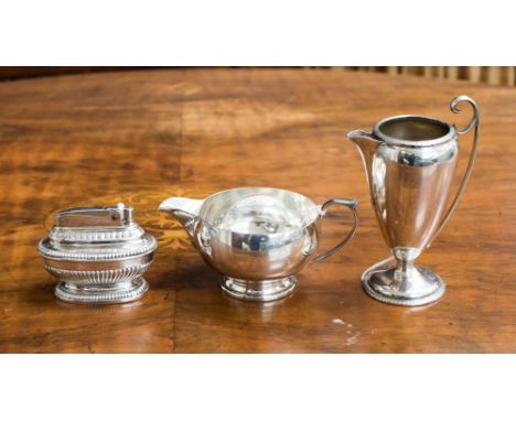 A George V silver jug with Celtic style decoration together with an ovoid silver cream jug, together with a Ronson slated tab