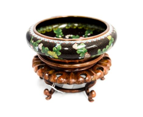 A cloisonne enamel floral bowl on wooden stand
