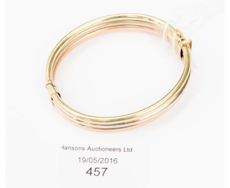 A 9ct three colour gold hinged bangle of three row tubular form, 22.0 grms