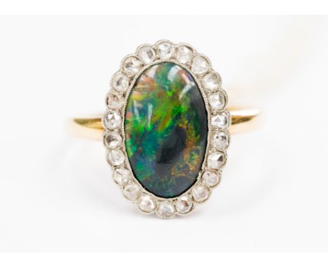 A black fine opal and diamond ring, the opal being approx. 15 mm long x 8 mm, set in possibly 18 carat gold