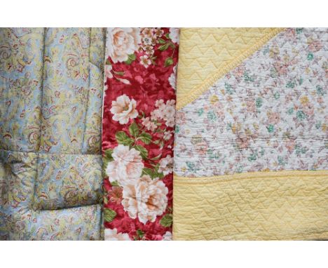 A 1930s/40s attractive eiderdown in a blue/pink paisley print edged in mauve and a lemon quilted bedspread with a pink/green 