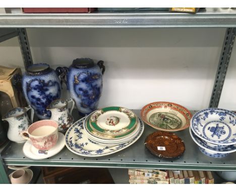 A shelf of china including Minton Delft blue and white tableware.