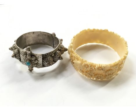 A white metal and turquoise Eastern bangle together with a white celluloid bangle.