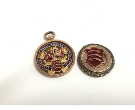 A 9 carat gold and enamel football medal from the Great Western Suburban Football League (14.1g) together with a silver medal