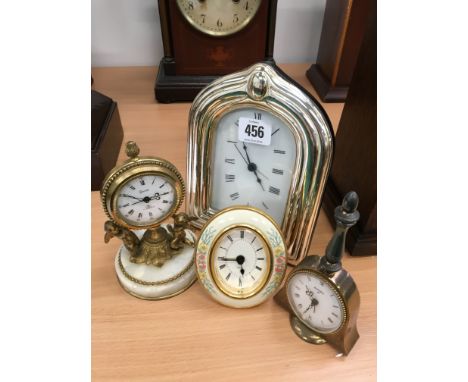 A modern silver framed mantle clock together with three small mantle clocks.