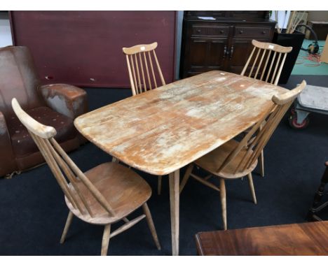 An Ercol light elm refectory dining table resting on four outswept legs together with four chairs with splat backs, cross str