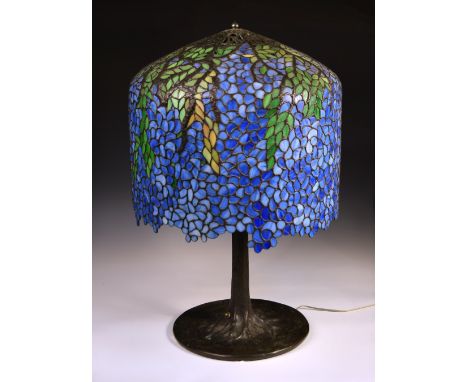 A Tiffany style 'Wisteria' table lamp, the shade of draping wisteria, in vivid blue leaded glass tiles, the top of open-work,