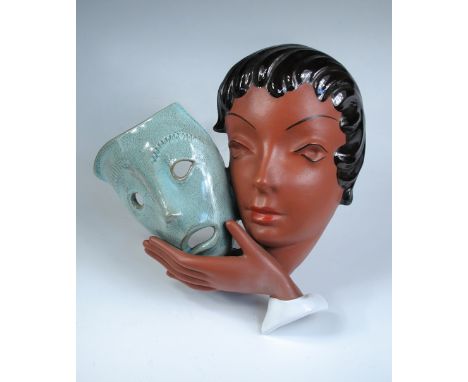 A Goldscheider Art Deco wall mask, the terracotta head of a young woman holds a theatrical mask to her cheek, printed marks 2