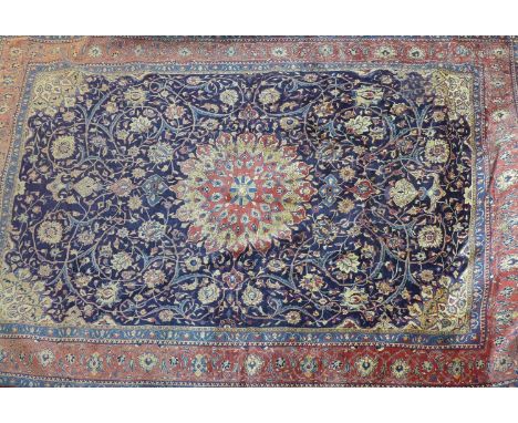 A North West Persian Sarouk carpet, double pendent medallion with repeating petal motifs on a sapphire field, within stylised