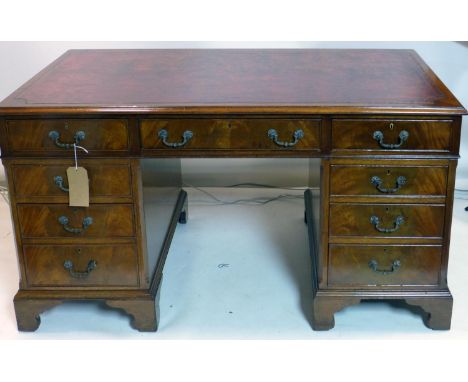 A Georgian style mahogany pedestal desk, with tooled leather top, raised on bracket feet, H.76 W.136 D.76cm 