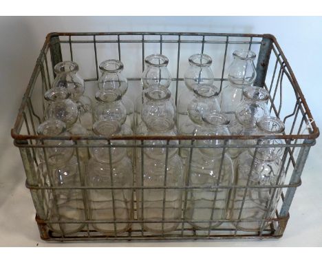 A collection of vintage glass milk bottles in vintage wire crate 