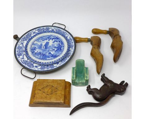 A miscellaneous collection of items to include a cast iron dog nut cracker, pair of blue and white plates, blue and white hot