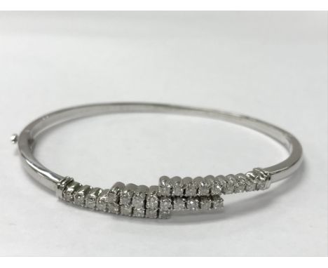 A white 18ct gold bangle with three rows of diamonds, 0.86ct in total. The total weight is approximately 12.85g.
