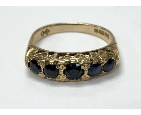 A 9ct gold ring set with five blue stones. The approximate ring size is K.