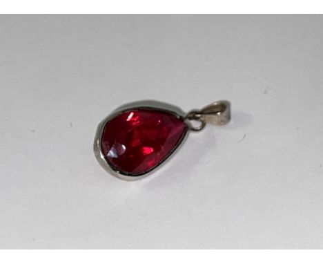 A large natural pear shaped ruby with a white metal pendant mount, 10mm x 15mm.